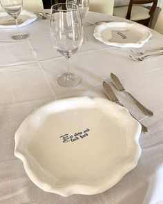 there is a white plate and silverware on the table