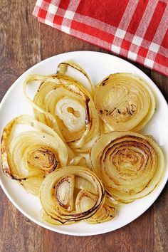 roasted onions on a white plate with a red and white checkered table cloth