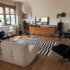 a living room filled with furniture and a flat screen tv sitting on top of a wooden floor