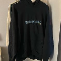 a black hoodie with the words astroworld on it hanging from a white wall