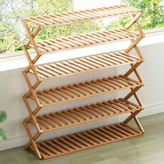 three tier bamboo shelf unit in front of a window