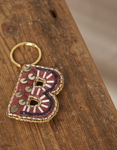 a wooden table with a metal keychain on top of it and an embroidered number