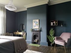 a bedroom with dark blue walls and wood flooring, a fireplace in the corner