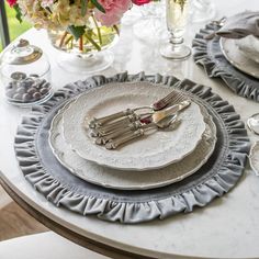 the table is set with silverware and flowers