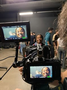 a woman is recording an event with a camera on the tripod in front of her