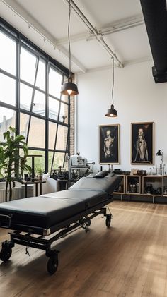 an empty hospital room with a bed in the middle and pictures on the wall behind it