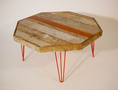 a wooden table with red hairpinks on it and a white wall in the background