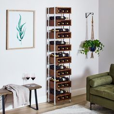 a living room filled with furniture and a wine rack next to a green chair in front of a painting on the wall