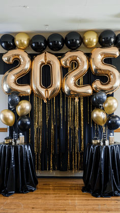 black, gold and white balloons with the number 20 on them are in front of a backdrop