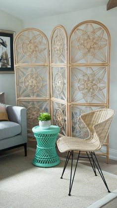 a living room with two chairs and a table in front of an iron screen wall