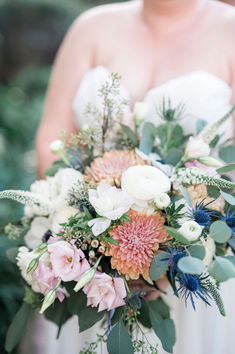 a bridal holding a bouquet of flowers and greenery