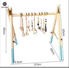 a wooden rack with beads and necklaces hanging from it's sides on a white background