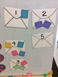 a bulletin board with different types of envelopes on it and numbers cut out from them