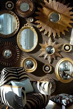 many mirrors are arranged on the wall with gold trimmings and starburst designs