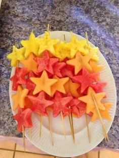 a white plate topped with star shaped food on top of a tile floor next to a counter