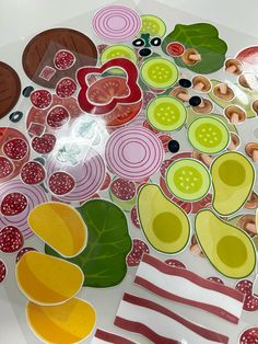 several different types of paper and buttons on top of a white table with red stripes