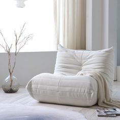 a white chair sitting in front of a window