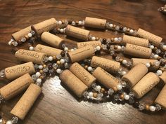 a bunch of wine corks that are sitting on a wooden table with beads around them