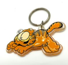 a keychain with a cartoon character on it's face and an orange tail