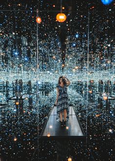 a woman standing on a platform in front of a large display of lights and bubbles