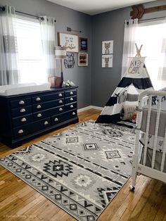 a baby's room with a teepee tent bed, dresser and crib