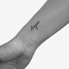 a black and white photo of a person's arm with the word hope tattooed on it