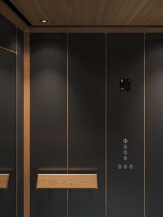 a bathroom with black walls and wooden shelves