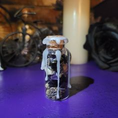 a jar filled with rocks sitting on top of a purple table