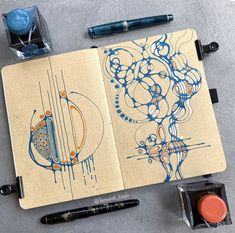 an open notebook sitting on top of a table next to marker pens and ink pads