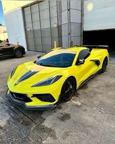 a yellow sports car parked in front of a garage