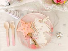 a pink plate topped with cookies and unicorn cutouts