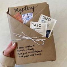 a person holding an envelope with some type of tazo written on it and tied in twine