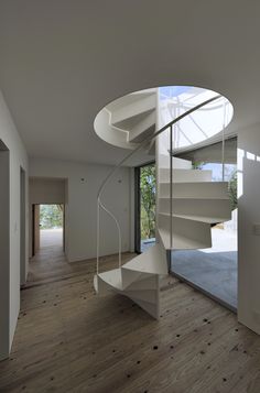 a white spiral staircase in an empty room