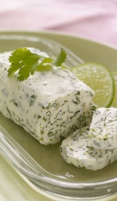 there is a piece of cheese on a plate with lemon wedges and parsley