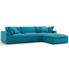 a blue sectional couch with pillows on the top and bottom part, in front of a white background