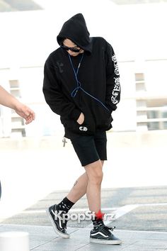 a man in black hoodie and shorts walking