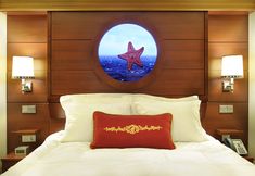 there is a bed with a starfish on it and two lamps next to the headboard