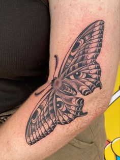 a butterfly tattoo on the arm with an eye in it's center and wings