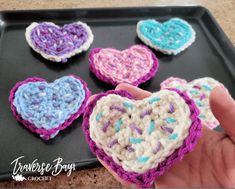 crocheted hearts are arranged on a tray