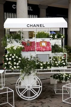 a cart with flowers on it sitting in front of a building