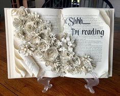 an open book with paper flowers on it