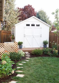 a backyard garden with a shed and landscaping