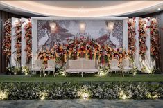 a decorated stage with chairs and flowers on it