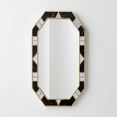 a black and white mirror sitting on top of a wall