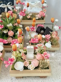 three wooden trays filled with flowers on top of a white carpeted floor next to a wall