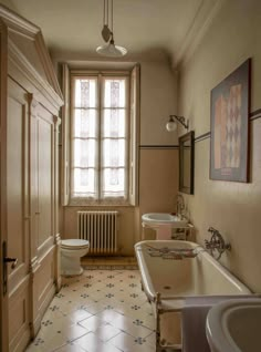 an old fashioned bathroom with white fixtures and tile flooring is shown in this image