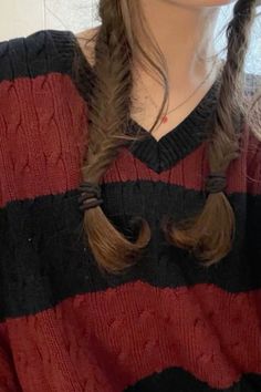 a woman with long hair wearing a red and black sweater