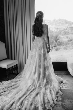 a woman in a wedding dress looking out the window