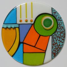 a colorful glass plate with an abstract design on the front and sides, in different colors