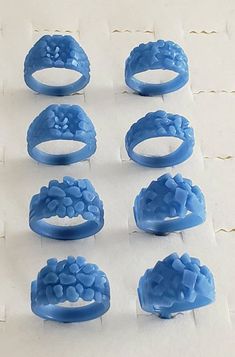 six blue rings with flowers on them sitting on a sheet of paper